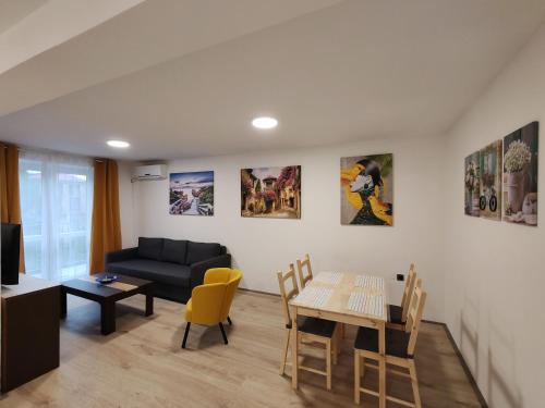 a living room with a couch and a table and chairs at Sweet house in Novi Sad