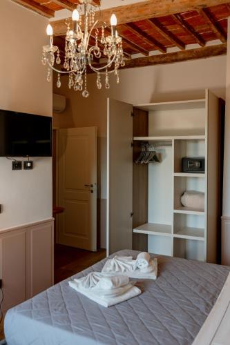 a bedroom with a bed and a chandelier at Neoclassico by Tiziana Monaldi in Pitigliano