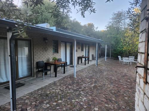 a patio of a house with a table and chairs at Mimosa Guesthouse in Colesberg