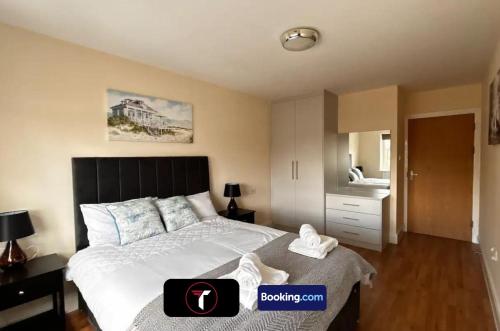a bedroom with a large bed with shoes on it at Stylish 2 Bedroom Flat By Tara Stays Short Lets & Serviced Accommodation Watford With Free Parking & Nearby Warner Studios in Watford