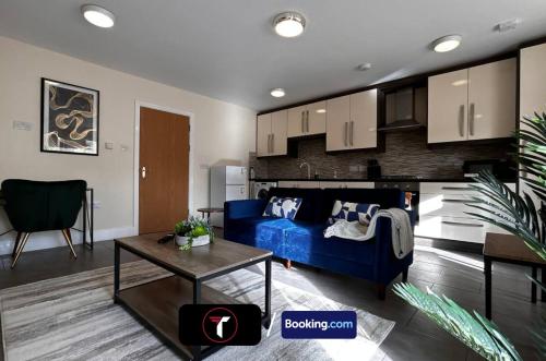 a living room with a blue couch and a table at Modern 2 Bedroom Flat By Tara Stays Short Lets & Serviced Accommodation Watford With Free Parking & Nearby Warner Studios in Watford