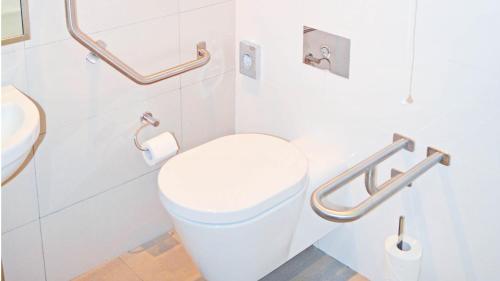 a white bathroom with a toilet and a sink at Holiday Inn Mauritius Mon Trésor by IHG in Blue Bay