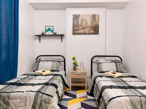 two beds sitting next to each other in a bedroom at Mesaverte Residences Cozy Studio Unit in Cagayan de Oro