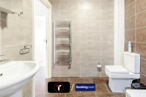 a bathroom with a white sink and a toilet at Stylish 2 Bedroom Flat By Tara Stays Short Lets & Serviced Accommodation Watford With Free Parking & Nearby Warner Studios in Watford