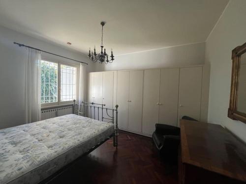 a bedroom with a bed and a chandelier at Casa Bianca con giardino a Magreta di Formigine in Magreta