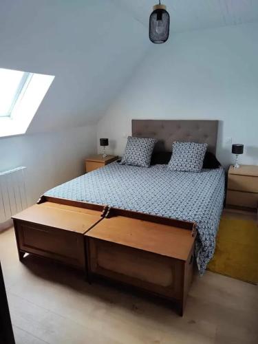 - une chambre avec un grand lit et un cadre en bois dans l'établissement Maison de Vacances à Guissény - Idéal pour Familles et Amis, à Guissény