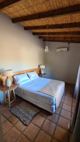 a bedroom with a large bed and a table at El Porvenir Wine Lodge in Cafayate