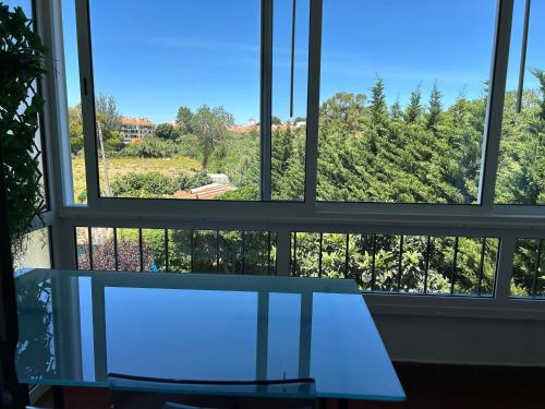 a glass table in front of a large window at 5minutos do jardim até ao mar in Parede