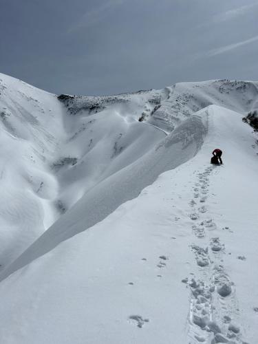 a person is walking down a snow covered mountain at Asakusa Sanso in Uonuma