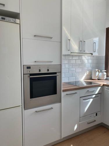 a kitchen with white appliances and white cabinets at Modern 1 bedroom sea view beach apartment in Limassol