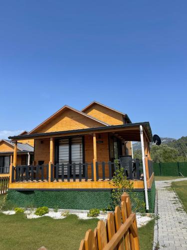 a wooden house with a fence in front of it at 101 Gün Kiralık Havuzlu Lake House kayacık in Dalaman