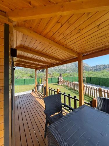 a wooden deck with a table and chairs on it at 101 Gün Kiralık Havuzlu Lake House kayacık in Dalaman