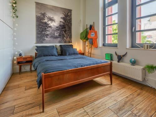 a bedroom with a bed with a blue comforter at Thisseion Lofts George in Athens