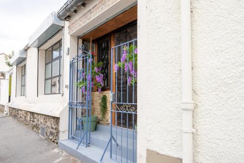een gebouw met een blauwe deur met bloemen erop bij Maison de rêve proche métro et RER in Alfortville