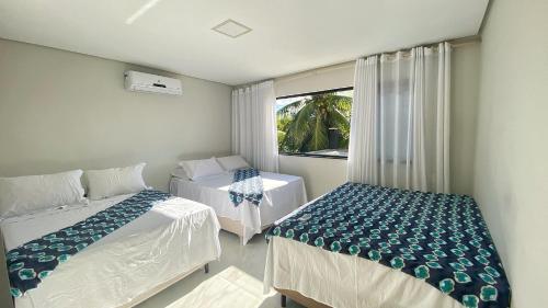 Giường trong phòng chung tại Casa Sonho de Praia Guarajuba