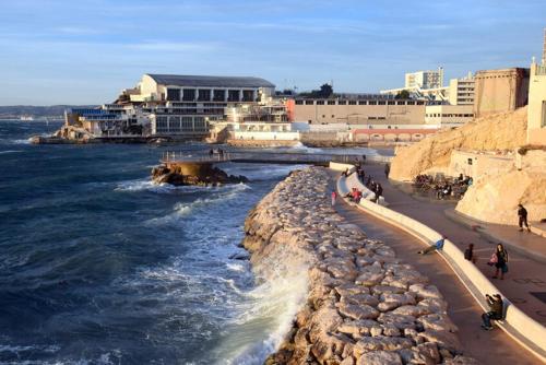 Un groupe de personnes marchant sur une plage au bord de l'océan dans l'établissement Le chant des vagues, à Marseille
