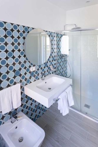 a bathroom with a sink and a shower and a mirror at Agorà Vulcano in Crosia