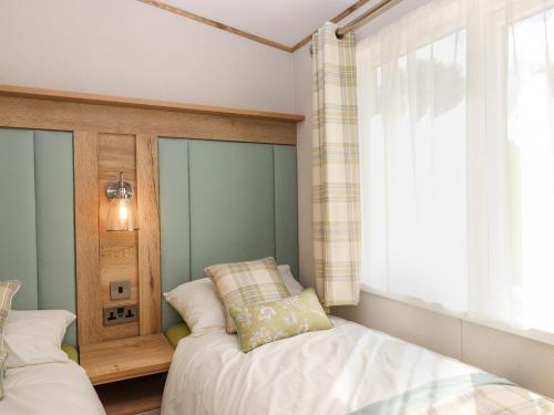 a bedroom with two beds and a window at Ambleside in Cullompton