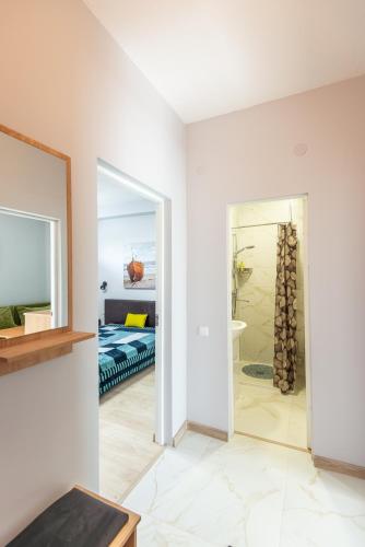 a white room with a mirror and a bedroom at Apartamentai pas Reginą in Palanga