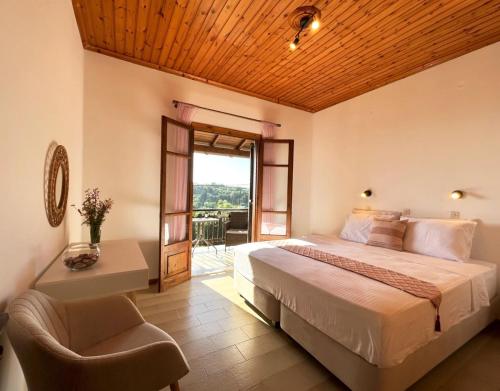 a bedroom with a bed and a chair and a window at Golden View Apartments in Arillas