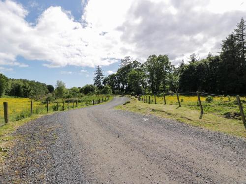a dirt road with a fence on the side at Moyle Lodge in Dalbeattie
