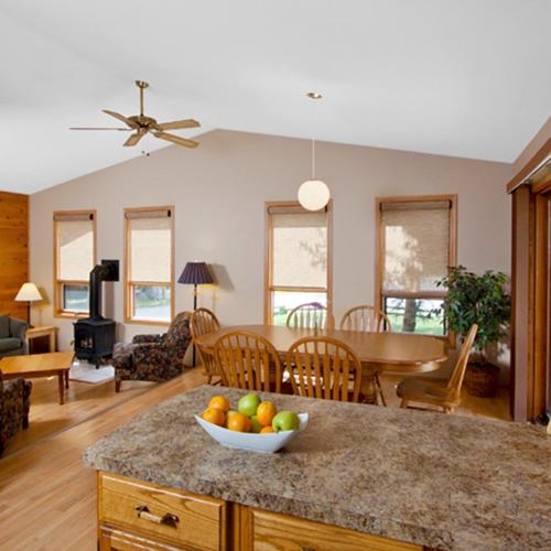 a kitchen and living room with a bowl of fruit on a counter at Overlander Mountain Lodge in Jasper