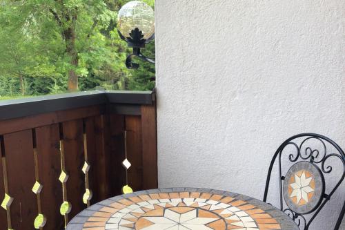 a table and chair on a balcony with a window at Schaffergut Appartements in Donnersbachwald