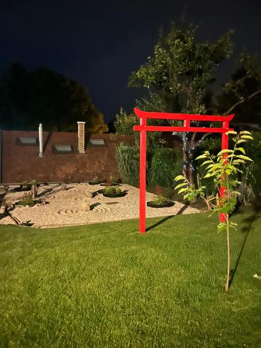 a red gate in the grass in a yard at ZEN apartman in Leányfalu