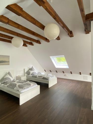 two beds in a room with white walls and wooden floors at Modernes Ferienhaus mit 2 Balkonen, Terrasse und Garten ! in Bochum