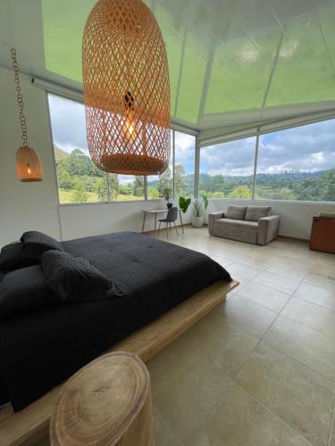 a bedroom with a large bed and a large window at El Rancho de Salento in Salento
