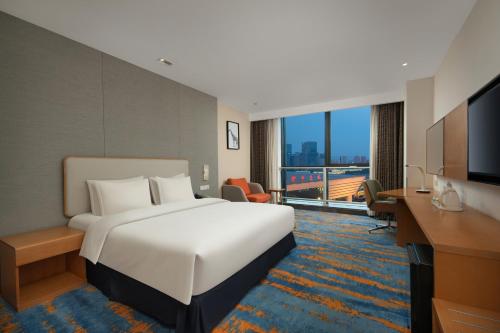 a hotel room with a large bed and a television at Holiday Inn Express Zhengzhou Zhengdong by IHG in Zhengzhou