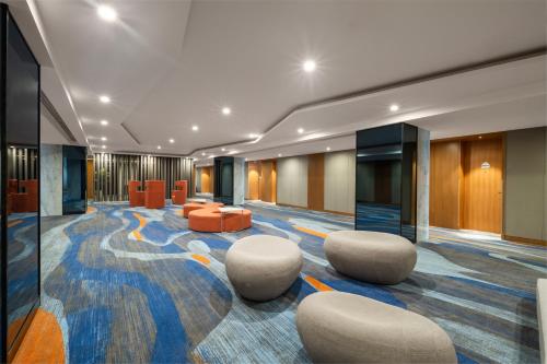 a lobby with couches and chairs in a building at Holiday Inn Express Zhengzhou Zhengdong by IHG in Zhengzhou