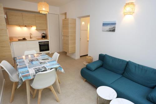 un salon avec un canapé bleu et une table dans l'établissement T2 neuf sur jardin proche plage, à Carqueiranne