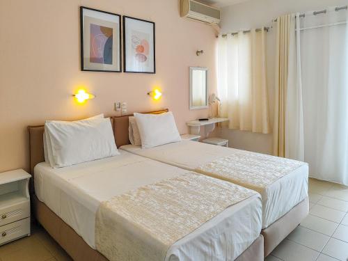 a bedroom with a large bed with white sheets at Al Mar in Skiathos Town