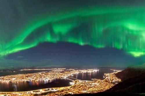eine Luftaufnahme der Aurora über einer Stadt in der Unterkunft New exclusive appartment with seaview in Tromsø