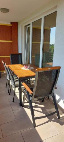 a wooden table and chairs on a patio at Apartma Vita in Moravske Toplice