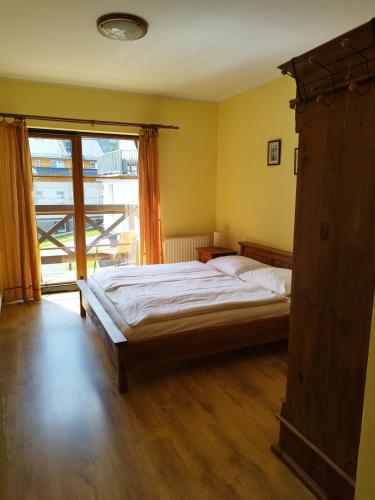 a bedroom with a bed and a large window at Willa Pokusa in Szklarska Poręba