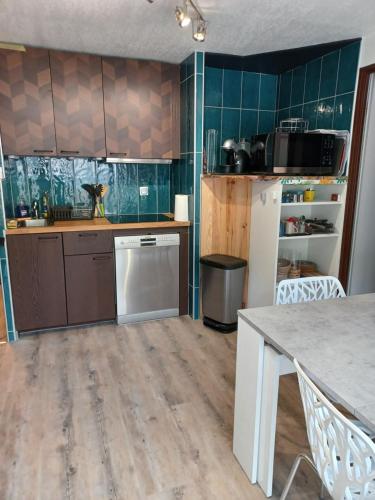 une cuisine avec un réfrigérateur blanc et une table dans l'établissement Aurette, à Saint-Lary-Soulan