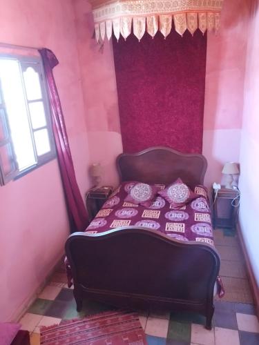 a bedroom with a bed in a pink room at La Maison Haute Larache Morocco in Larache
