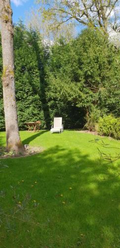 a white bench sitting in the grass next to a tree at Just for sleep in Liège