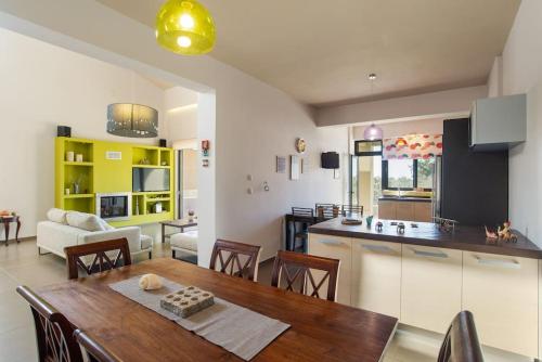 a kitchen and living room with a wooden table and a dining room at Dream's House - Villa with Pool & Stunning Views in Daratso