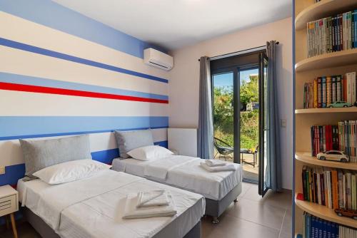 a room with two beds and a book shelf at Dream's House - Villa with Pool & Stunning Views in Daratso
