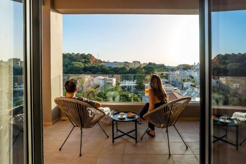 a man and a woman sitting in chairs on a balcony at Dream's House - Villa with Pool & Stunning Views in Daratso