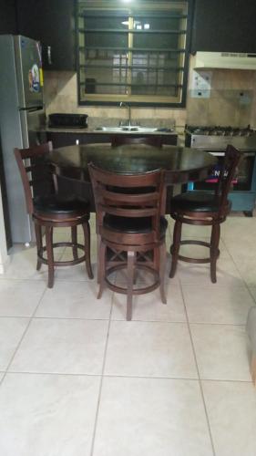 a dining room table with two chairs and a sink at Tu casa Menus de Boquete te espera in Alto Boquete