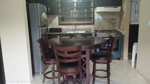 a kitchen with a table and chairs and a refrigerator at Tu casa Menus de Boquete te espera in Alto Boquete