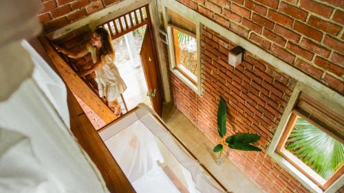 a woman standing in the doorway of a brick building at Eco Breeze - Unawatuna in Unawatuna