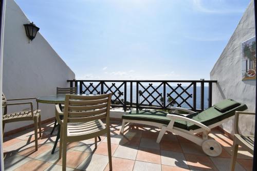 a balcony with chairs and a table on a balcony at Rocas del Mar 408 in Costa Del Silencio