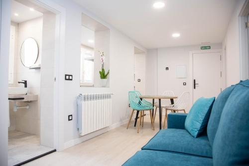 ein Wohnzimmer mit einem blauen Sofa und einem Tisch in der Unterkunft Pregonero Urban Suites - Azul in Soria