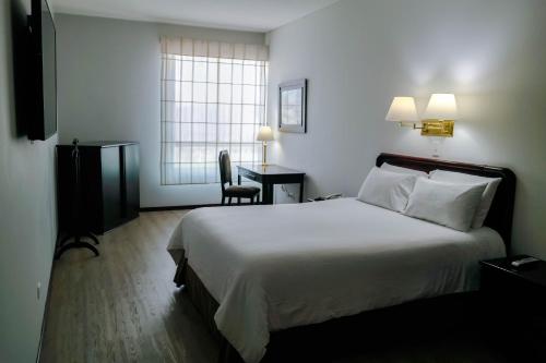 a hotel room with a large bed and a desk at Hotel Internacional La Triada in Bucaramanga