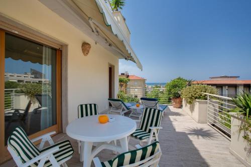 a patio with a table and chairs on a balcony at Hotel Bacco in Lido di Camaiore